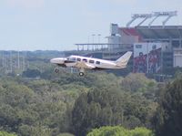 N100P @ TPA - PA-31-350 taking off at Tampa with Raymond James (Tampa Bay Buccaneers NFL team) Stadium in background